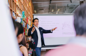 business presentation with asian man standing in front of the team talking